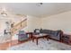 Living room with hardwood floors, large sofa, and stairway to the second floor at 3866 Starfield Ln, Las Vegas, NV 89147