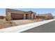 Single-story home featuring a brick driveway, desert landscaping, and a two-car garage at 4485 E Brusca Way, Pahrump, NV 89061