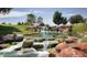 Beautiful community water feature with cascading waterfalls, lush greenery, and natural rocks at 4485 E Brusca Way, Pahrump, NV 89061