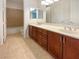 Modern bathroom featuring dual sinks with wood cabinets and a shower-tub combination at 7719 Windy Meadow Ave, Las Vegas, NV 89178