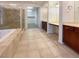 Luxurious bathroom showcasing a glass shower, soaking tub, dual vanities, and a walk-in closet at 7719 Windy Meadow Ave, Las Vegas, NV 89178
