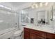 Bright bathroom featuring a marble countertop, stylish vanity, and a bathtub with a glass door at 8290 Gagnier Blvd, Las Vegas, NV 89113