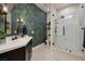 Modern bathroom featuring stylish wallpaper, a sleek vanity, and a glass-enclosed shower with beautiful tile work at 8290 Gagnier Blvd, Las Vegas, NV 89113