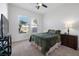 Cozy bedroom with neutral carpet, two windows, and a wood nightstand at 8290 Gagnier Blvd, Las Vegas, NV 89113