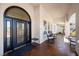 Elegant front porch and door featuring an arched entry, seating, and desert landscaping at 8290 Gagnier Blvd, Las Vegas, NV 89113