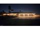 Exterior nighttime view showcasing a beautiful home with palm trees and a four-car garage at 8290 Gagnier Blvd, Las Vegas, NV 89113