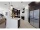 Bright modern kitchen featuring an island with a countertop, stainless steel appliances, and dark cabinets at 8290 Gagnier Blvd, Las Vegas, NV 89113