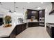 Spacious gourmet kitchen with dark cabinets, modern stainless steel appliances, and a large island with countertop seating at 8290 Gagnier Blvd, Las Vegas, NV 89113