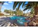 Beautiful pool and spa surrounded by lush landscaping and palm trees, perfect for relaxation and entertaining at 8290 Gagnier Blvd, Las Vegas, NV 89113
