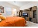 Comfortable bedroom with a custom wall unit, large windows, plush carpet, and orange bedding at 905 Belleforte Ln, Las Vegas, NV 89138