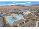 An aerial view shows a community pool, clubhouse, and lounge area with mountains in the background at 905 Belleforte Ln, Las Vegas, NV 89138