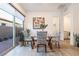 Bright dining area with a glass table, zebra-print chairs, and sliding glass door to outdoor area at 905 Belleforte Ln, Las Vegas, NV 89138