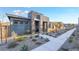 Single-story home showcasing modern architecture, stone detail, and xeriscaping for low-maintenance appeal at 905 Belleforte Ln, Las Vegas, NV 89138