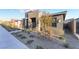 Contemporary single-story home featuring stone accents and desert landscaping with easy-care gravel at 905 Belleforte Ln, Las Vegas, NV 89138