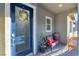 Welcoming front porch with a blue door, wreath, and a cozy sitting area at 905 Belleforte Ln, Las Vegas, NV 89138