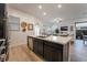Open concept kitchen with modern dark cabinets, spacious island, and view of the living room at 905 Belleforte Ln, Las Vegas, NV 89138