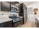 Kitchen featuring stainless steel appliances, quartz counters, gas range, and dark cabinetry at 905 Belleforte Ln, Las Vegas, NV 89138