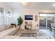 Cozy living room with a modern sectional, large windows, and sliding doors to the backyard at 905 Belleforte Ln, Las Vegas, NV 89138
