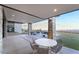 Covered patio features stone columns, outdoor dining space, and stunning city views at 905 Belleforte Ln, Las Vegas, NV 89138