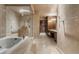 Elegant bathroom features a soaking tub, glass shower, vanity, and tile flooring throughout at 9103 Alta Dr # 102, Las Vegas, NV 89145