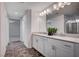 Elegant bathroom featuring a double sink vanity, framed mirrors, and tiled floors at 10306 Coastline Creek Ct, Las Vegas, NV 89141
