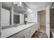 Bright bathroom with double sinks, white cabinets, tiled floors, and a large mirror, creating a spacious feel at 10306 Coastline Creek Ct, Las Vegas, NV 89141