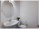 Bathroom with a pedestal sink, decorative mirror, and modern toilet at 10306 Coastline Creek Ct, Las Vegas, NV 89141