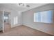 Bedroom with neutral carpet and white walls has a window with blinds and a door looking onto the upstairs hall at 10306 Coastline Creek Ct, Las Vegas, NV 89141