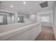 Bright hallway boasts neutral carpet, white walls and trim, and lots of natural light from nearby windows at 10306 Coastline Creek Ct, Las Vegas, NV 89141