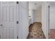 Hallway with tile flooring leading to rooms with neutral carpet and white doors at 10306 Coastline Creek Ct, Las Vegas, NV 89141