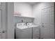 Efficient laundry room featuring a washer, dryer, and built-in shelving at 10306 Coastline Creek Ct, Las Vegas, NV 89141