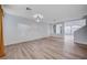 Spacious living room features wood floors, a modern light fixture, and views into adjoining rooms at 10306 Coastline Creek Ct, Las Vegas, NV 89141