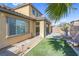 Inviting backyard featuring a covered patio, artificial grass, and desert landscaping at 12836 Alcores St, Las Vegas, NV 89141
