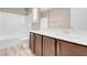 Bright bathroom with a modern vanity, wood-look floors, and a shower-tub combo at 12836 Alcores St, Las Vegas, NV 89141