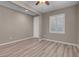 Bedroom featuring wood-look floors and a ceiling fan, with a white door and shuttered window at 12836 Alcores St, Las Vegas, NV 89141