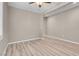 A neutrally painted bedroom featuring wood-look floors and a ceiling fan with ample natural light at 12836 Alcores St, Las Vegas, NV 89141