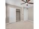 Neutral bedroom featuring plush carpeting, a ceiling fan, and a sliding-door closet at 12836 Alcores St, Las Vegas, NV 89141