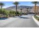 Gated community entrance featuring desert landscaping, mature trees and mountain views at 12836 Alcores St, Las Vegas, NV 89141