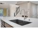 Modern kitchen island with sink and faucet, view of staircase and stainless steel appliances in background at 12836 Alcores St, Las Vegas, NV 89141