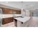 Modern kitchen with a center island, pendant lighting, stainless appliances, and wood-look flooring at 12836 Alcores St, Las Vegas, NV 89141