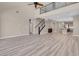 A spacious living room featuring wood-look floors, a staircase, and an open layout leading into the kitchen area at 12836 Alcores St, Las Vegas, NV 89141