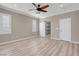 Main bedroom featuring wood-look floors, ceiling fan, shuttered windows, and access to ensuite bathroom at 12836 Alcores St, Las Vegas, NV 89141
