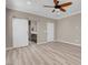 Main bedroom with wood-look floors, a ceiling fan, and access to a bathroom with barn door at 12836 Alcores St, Las Vegas, NV 89141