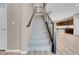 Carpeted staircase with metal railing leading to an open floorplan and kitchen area at 12836 Alcores St, Las Vegas, NV 89141