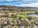 Stunning aerial view of a neighborhood with lush golf course, water features, and mountain views at 1477 Foothills Village Dr, Henderson, NV 89012
