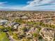 An aerial view showing a neighborhood, with a view of Las Vegas in the distance, showcasing the area's landscape at 1477 Foothills Village Dr, Henderson, NV 89012