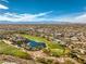 Expansive aerial view showcasing the lush golf course and the city skyline in the distance under a bright blue sky at 1477 Foothills Village Dr, Henderson, NV 89012