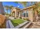 An inviting backyard featuring a covered patio, manicured landscaping, and a small section of artificial turf at 1477 Foothills Village Dr, Henderson, NV 89012