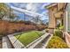 Well-manicured backyard with artificial turf and tasteful landscaping, offering a serene and private outdoor space at 1477 Foothills Village Dr, Henderson, NV 89012
