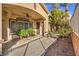A covered backyard patio with an overhead fan looks out onto well-maintained landscaping and shade trees at 1477 Foothills Village Dr, Henderson, NV 89012